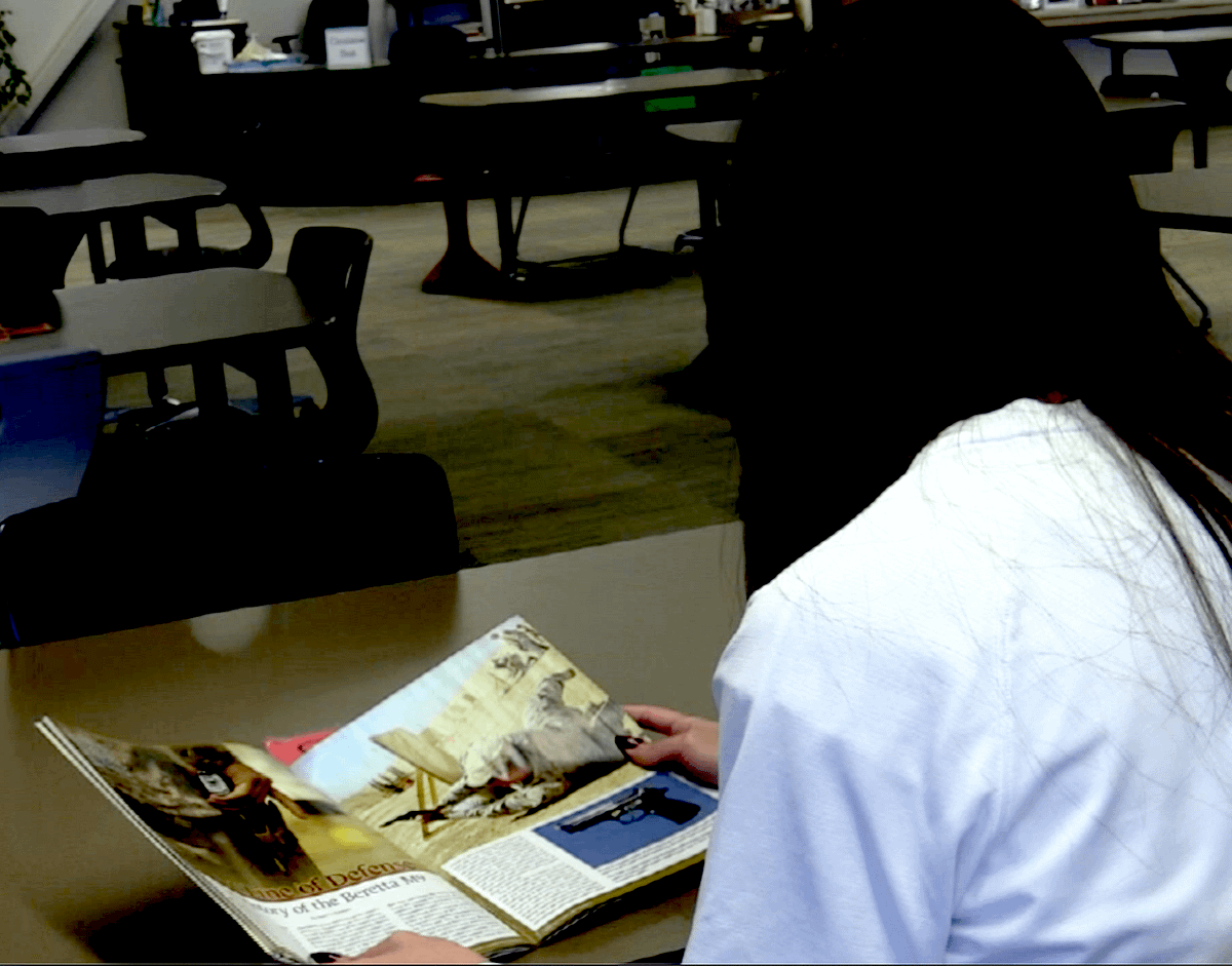 An EHS student reads an article about gun safety. 